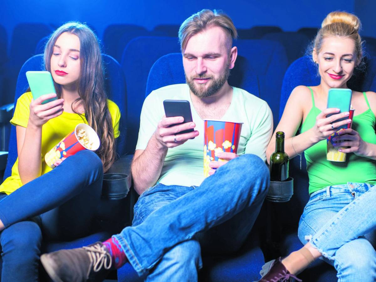 In front of the big screen with a small smartphone